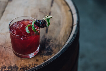 blackberry lime bourbon whiskey smash cocktail on barrel
