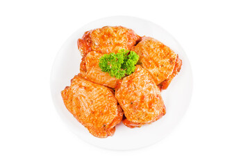 Raw marinated in red sauce chicken thighs on a white plate, on a white isolated background. Top of view. Raw chicken marinated. Isolated object, copy space.Chicken semi-cooked thighs.