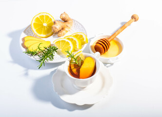 Ginger, lemon and herbs infusion tea served in a white porcelain cup. Copy space. 