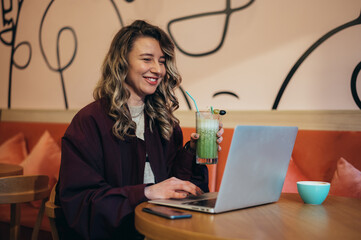 Young woman working on her laptop in a cafe
