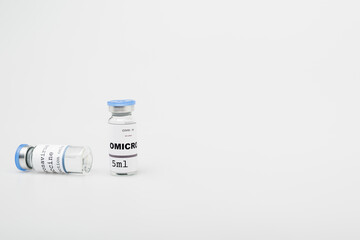 vials with covid-19 omicron variant vaccine on grey background with copy space.