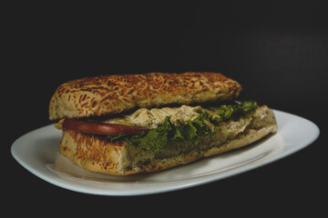 Delicious chicken sandwich on black background