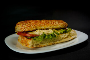 Delicious chicken sandwich on black background