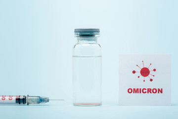 syringe, vaccine vial and card with omicron lettering and bacteria icon on blue.