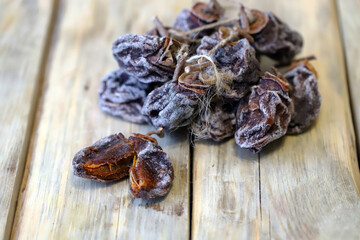 Dried persimmon on a wooden surface. Close.