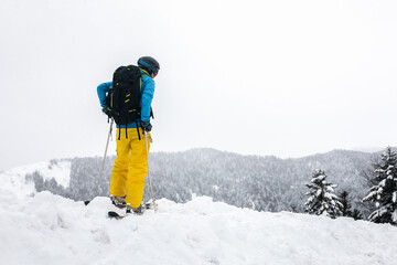 Young caucasian woman looking a winter landscape after a heavy snow storm on the Pyrenees.