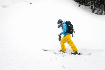 Young caucasian skier walking a snow wall at the Pyrenees.