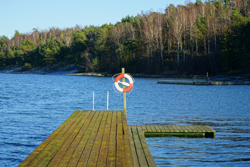 Safety equipment. Bright red safe lifebuoy on swimming pier