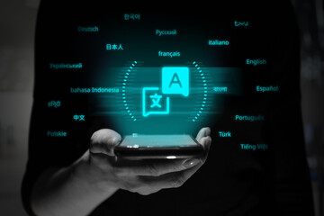 A person is holding a smartphone with a holographic projection of the translator application symbol.