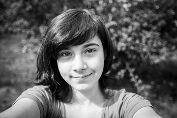 A girl takes a selfie in the Park. Black and white photo.