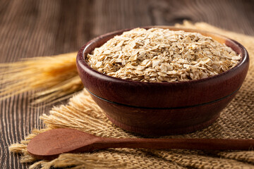 Oat flakes in wooden bowl.