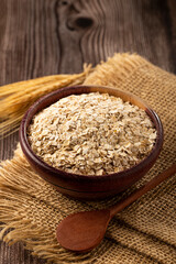 Oat flakes in wooden bowl.