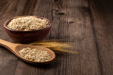 Oat flakes in wooden bowl.