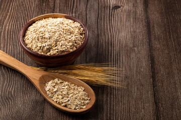 Oat flakes in wooden bowl.