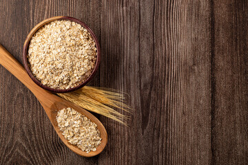 Oat flakes in wooden bowl.