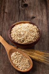 Oat flakes in wooden bowl.