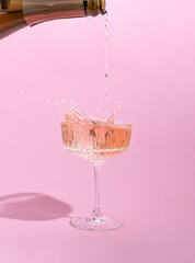 Pink champagne pouring in a glass. Creative minimal concept