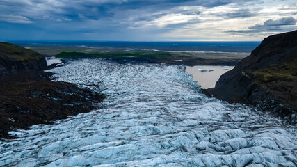 Beautiful Cinematic Aerial view of the massive Svinafellsjokull Glacier in Iceland and its lagoon caused by global warming