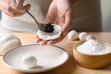 Hand making Tangyuan, Chinese dessert made of ball glutinous rice flour and filled with black sesame
