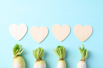 Organic white radish or Chinese radish with heart shape on light blue background, love concept, Valentine day