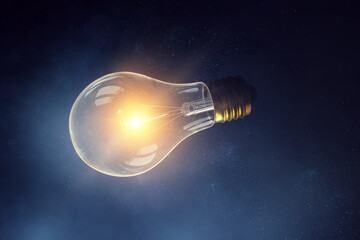 Huge light bulb glowing in the darkness