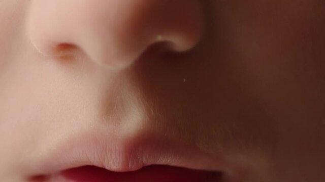 Close up of a young child's nose and mouth as he starts to smile.