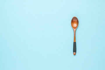 Beautiful wooden spoon on a light blue background. Space for text.