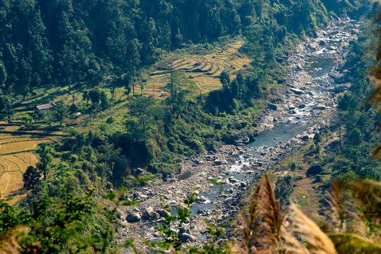 Top view of Joldhaka river flowinf beneath at India Bhutan border with agricultural lands on the side . Image shot at Jhalong, North Bengal - Dooars West Bengal , India