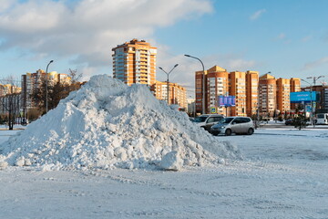 A large pile of snow lies on the street after a snowfall with residential district in the...