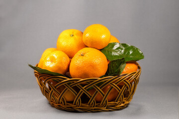 Sweet juicy tangerines with green leaves in a wooden basket.Home gardening.