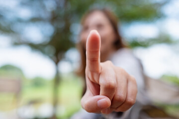 Blurred image of a woman touching or pointing finger at you
