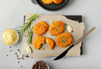 Board with tasty lentil cutlets on grey background