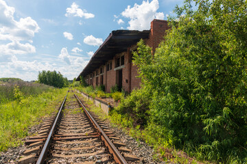 Fototapeta na wymiar railroad tracks next to an abandoned building