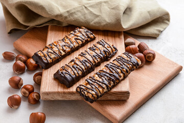 Boards with tasty chocolate nut bars on grunge background