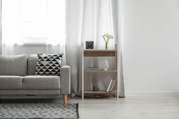 Interior of living room with sofa, shelving unit and window