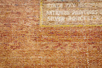 Refurbished Red Brick Wall with Faded Painted Sign