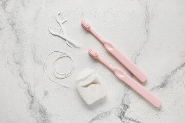 Dental floss with toothpicks and brushes on grunge background