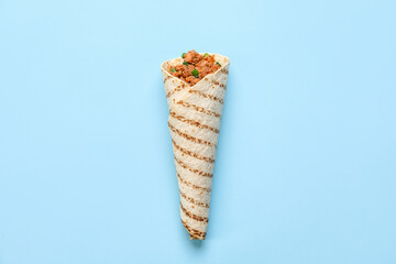 Tasty burrito on blue background