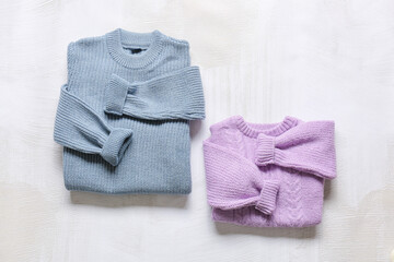Folded children's sweaters on light background