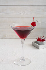Glass of tasty Manhattan cocktail on light background