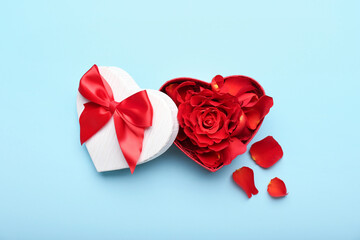 Gift box for Valentine's Day with rose petals on blue background