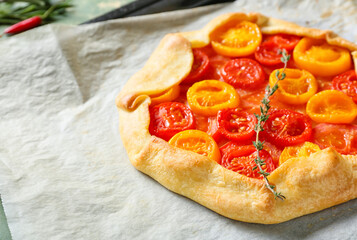 Baking tray with tasty tomato galette on table, closeup
