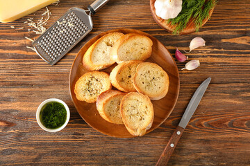 Plate of tasty croutons on wooden background