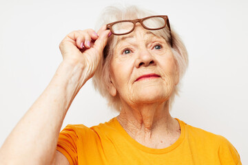 Portrait of an old friendly woman health lifestyle eyeglasses treatment light background