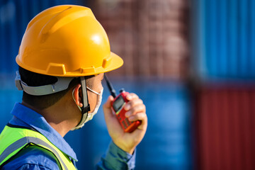 Industrial workers holding walkie talkies to coordinate.