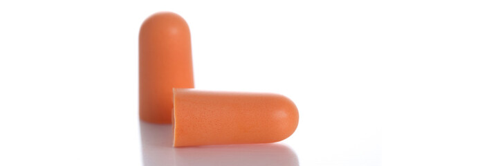 Two orange soft ear plugs on white background