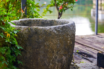 Flower pots and boulevards decorated with crock pots and stone millstones in the park