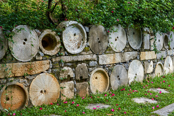 Flower pots and boulevards decorated with crock pots and stone millstones in the park