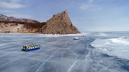 A group of tourists lies next to Khivus on the ice of Lake Baikal in winter. Russian Winter