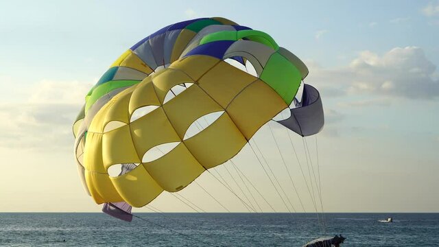 People parasailing in the wind on the beach in the evening.at phuket thailand